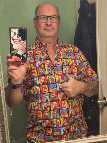 Reviewer gives a thumbs-up in a mirror selfie while wearing the colorful 'Artistic Rebellion' short sleeve shirt.