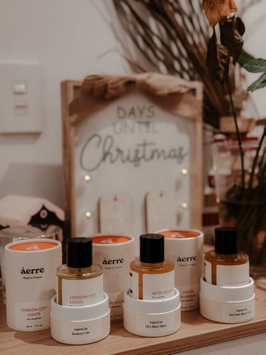 Customer's London City Lights perfume bottle and packaging on a wooden surface with other fragrances and festive decor.