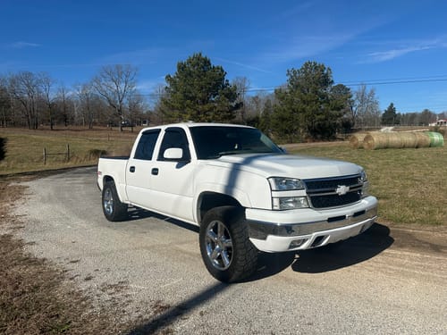 Customer's white Chevy Silverado with a wide stance from the 2" Hubcentric Wheel Spacers, viewed from the front quarter.