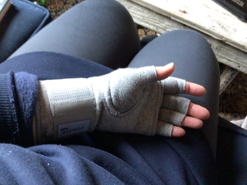 Customer wearing the grey Premium Bamboo Wrist Sleeve over a compression hand sleeve for support.