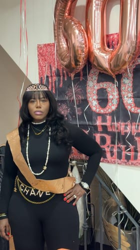 Reviewer posing in the black long-sleeved NW Sculpt Jumpsuit at a birthday celebration.