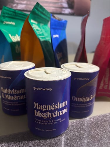 Avis d'un client sur le pot de Magnésium Bisglycinate bleu, posé devant d'autres suppléments de la marque.