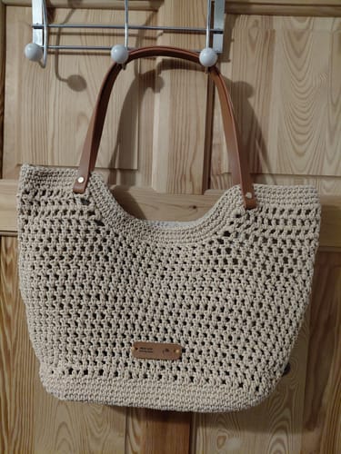 Customer's completed beige Sunny Beach Tote from the CrochetPark™ kit hanging on a door.