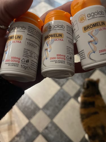 Un cliente tiene in mano tre flaconi dell'integratore Bromelin Ultra di Agolab, mostrando l'etichetta del prodotto.