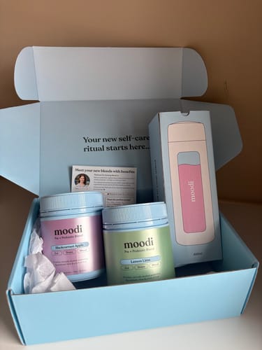 Customer's unboxing of the Classic Pre + Probiotic Bundle, showing two jars and a bottle in a blue branded box.