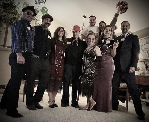 Reviewer and guests in vintage 1920s costumes playing the Murder Mystery Game Kit.