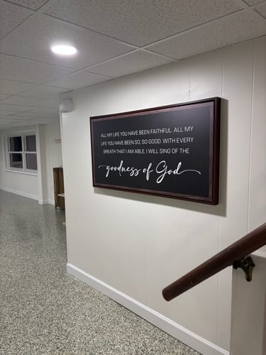 Reviewer's framed Goodness of God Faith Sign II canvas hanging on a white hallway wall.