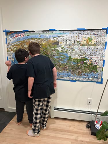 Customer's two children examining the World's Greatest Search & Discover - USA Edition poster on a wall.