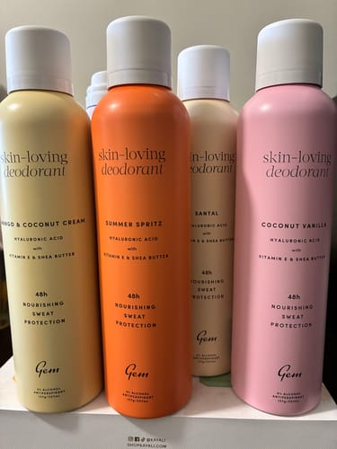 Reviewer's collection of four colorful Gem brand skin-loving deodorant sprays.