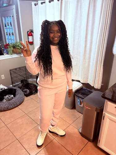 Customer smiling with long, wavy Human Crochet Hair Deep Wave styled in high pigtails.