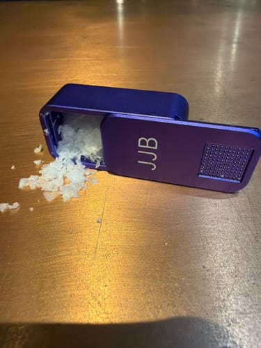 Reviewer's personalized purple case, open on a table and filled with flaked sea salt.