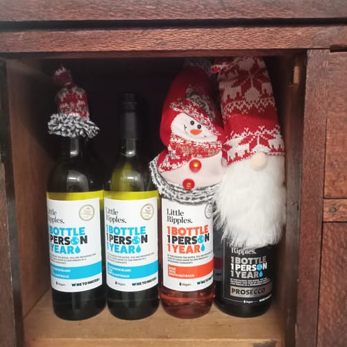 Customer's festive display of Little Ripples wine bottles, including Sauvignon Blanc and Rosé, wearing fun Christmas bottle toppers.