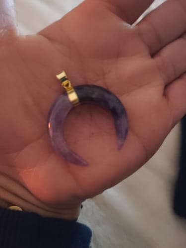 Cliente présentant le Pendentif Améthyste Lune dans le creux de sa main.