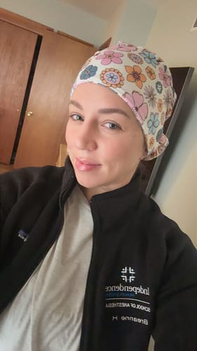 Reviewer wearing the colorful DuoStyle Scrub Hat with a Petal Power floral pattern.