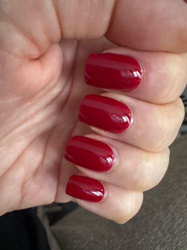 Customer's hand showing off the glossy, red Rosy Cheeks press-on nails.