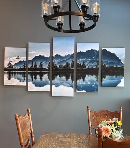 Customer's Misty Reflection canvas grouping hung on a dark gray wall over a wooden dining table.