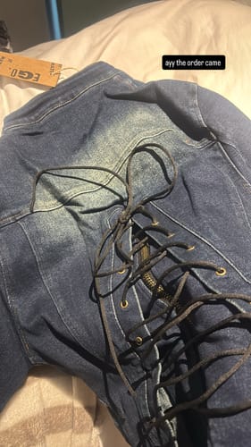 Close-up of the customer's blue denim VILLAIN MOTO JACKET, showing the black laced-up back detail.