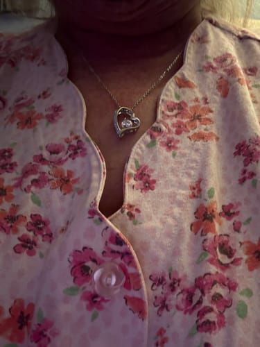 Close-up of a reviewer wearing the forever love necklace with a heart-shaped pendant.