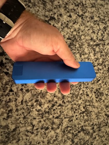 Customer holding the closed blue metal Weekly Case in their hand, showing its size against their palm.