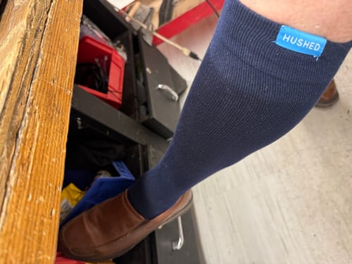 Reviewer wearing a dark blue Performance Eucalyptus Compression Sock that reaches up to their knee.