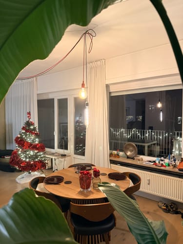 Klantfoto van de House Nordic Osaka eettafel in zijn ronde, niet-uitgeschoven vorm, opgesteld in een eetkamer.