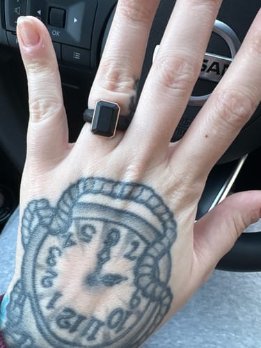 Reviewer's hand wearing the black Emerald Collection silicone ring with a rose gold metal frame.