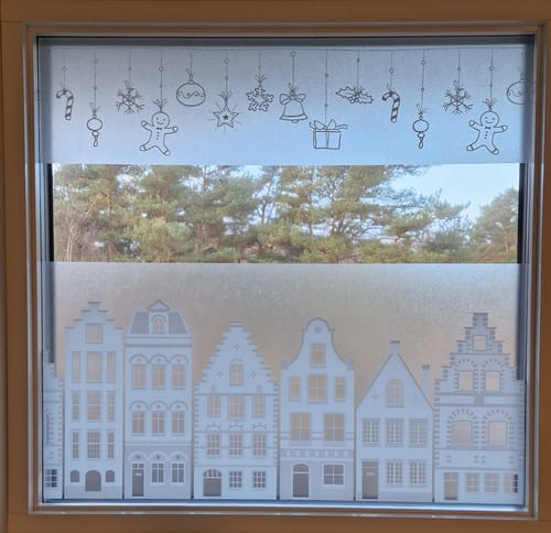 Kundens vindu med den koselige Limited Static winter garland-vindusfolien som viser hus og julepynt.