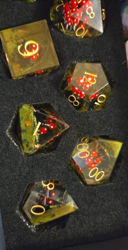 Customer's Red Mushroom Resin Dice Set with gold numbers, sitting in a black foam holder.