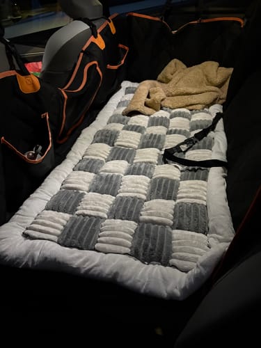 Customer's plush backseat dog bed with a gray and white checkered pattern, fitted inside a car's backseat hammock.