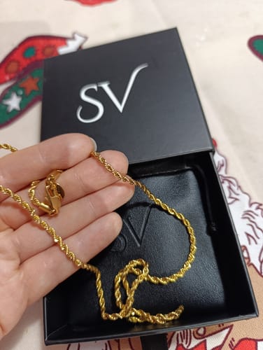 Cliente sosteniendo la Cadena Rope Oro sobre su caja de empaque negra.