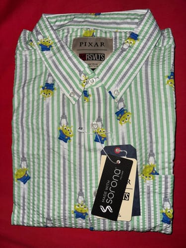 Customer's folded Toy Story 'The Claaaaaw' seersucker shirt showing the striped pattern and alien characters.