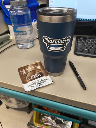 Customer's single Mylar Pouch resting on a desk next to a blue tumbler and a pen in an office setting.