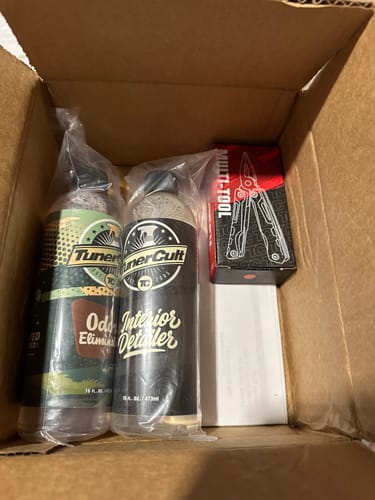 Customer's MULTI-TOOL RED/BLK shown in its red and black box inside a larger shipping carton with other items.