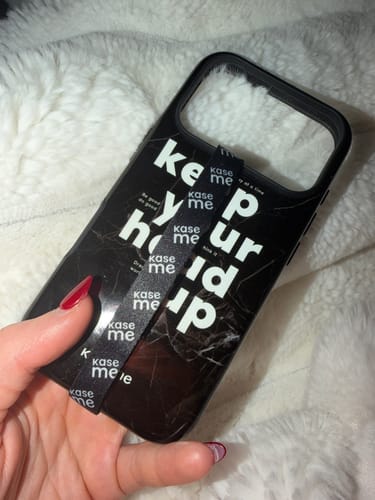 Customer holding the black Mindset phone case with a marble design and motivational white text.