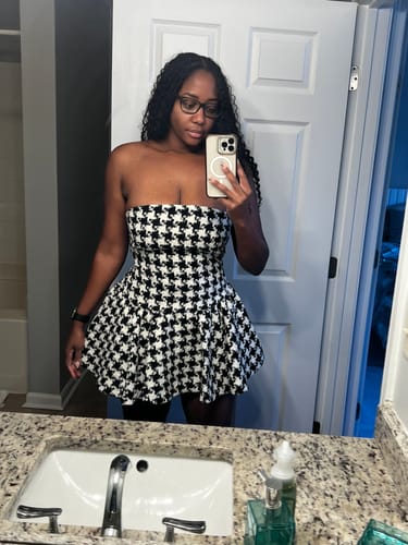 Reviewer taking a mirror selfie in the black and white Houndstooth Peplum Tube Mini Dress.