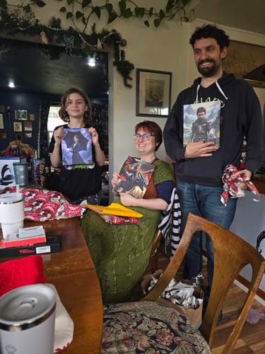Customer and family smiling happily while holding up their new personalized portraits, including The Celtic Chieftain.