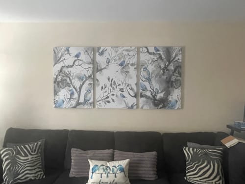 Customer's 'Lucky Blue Bird' Framed Canvas Set of 3 hanging on a wall above a dark sofa.