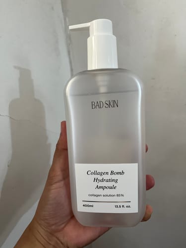 Customer holding the large 400ml bottle of Bad Skin Korean Collagen Bomb Hydrating Ampoule.