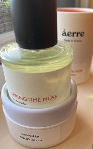 Customer's close-up of the Springtime Muse perfume bottle, showing the clear bottle and label, with packaging in the background.