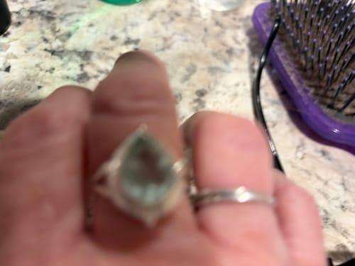 Customer's blurry close-up of the Teardrop Aquamarine Ring on their finger.