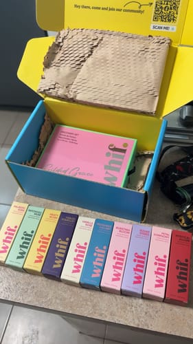 Customer's collection of colorful perfume boxes, including Majestic Aura, displayed on a counter.