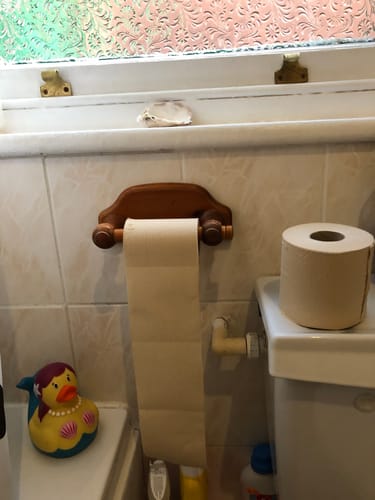 Customer's Unbleached Bamboo Toilet Paper on a holder, with a spare roll on the toilet.
