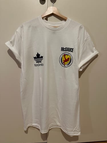 Customer's white unisex t-shirt on a hanger, showing the custom front print.