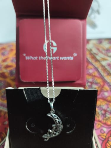 Reviewer's Oxidised Silver Unwind Moon Pendant with its box chain displayed in the original red and black packaging.