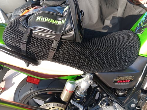 Customer's black Wind Rider Seat Cover installed on a green motorcycle, with a bag strapped to the back.