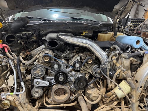 Reviewer's shiny SPE Motorsport Intake Piping Kit installed in a partially disassembled Powerstroke engine.