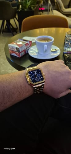 A close-up of a customer's wrist wearing the Oceaneva Tenuis watch with its blue dial and rose gold case.