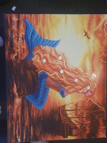 Reviewer's finished 'Mermaid Dreams' crystal art canvas, featuring a blue-tailed mermaid against a vibrant, fiery background.