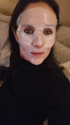 Eine Kundin, die eine weiße Kollagen-Boosting-Maske zur Schau stellt.