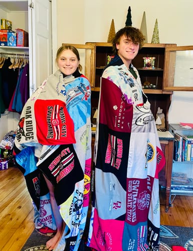 Customer photo of two people wrapped in colorful Premium T Shirt Quilts from swimming shirts.